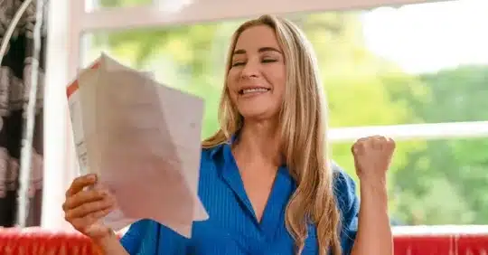 Homeowner smiling while reviewing a lower home energy bill