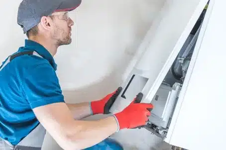 Technician installing a home furnace during a heating system replacement